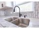 Close-up of kitchen sink area with marble countertops, subway tile backsplash, and modern faucet at 4501 20Th S Ave, St Petersburg, FL 33711