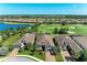 Stunning aerial view of homes overlooking a golf course and water feature on a sunny day in a well-manicured community at 4607 Benito Ct, Bradenton, FL 34211