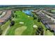 A high altitude view of a golf course community featuring a large pond and well-manicured green spaces at 4607 Benito Ct, Bradenton, FL 34211