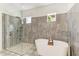 Spa-like bathroom boasts a soaking tub, walk-in shower, stone tile, and modern fixtures at 4607 Benito Ct, Bradenton, FL 34211