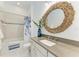 Bathroom featuring modern fixtures, a decorative mirror, and a shower-tub combination with stylish curtains at 4607 Benito Ct, Bradenton, FL 34211