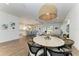 Open-concept dining area with a rattan chandelier, tile flooring, and kitchen views at 4607 Benito Ct, Bradenton, FL 34211