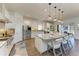 Modern white kitchen with stainless steel appliances, a large island, and bar stool seating at 4607 Benito Ct, Bradenton, FL 34211