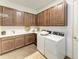 Well-organized laundry room featuring wood cabinetry, a sink, folding space, plus two modern, white appliances at 4607 Benito Ct, Bradenton, FL 34211