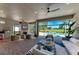 An open-air living room with fireplace, wet bar, ceiling fans, and expansive views of the private pool at 4607 Benito Ct, Bradenton, FL 34211