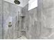 Contemporary gray tiled shower with dual showerheads and a built-in shower seat at 4607 Benito Ct, Bradenton, FL 34211