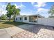 A single-story house featuring a paved driveway, screened porch, and a fenced backyard at 5001 15Th N Ave, St Petersburg, FL 33710