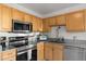 Close up view of kitchen with stainless appliances, gray granite counters, and wood cabinets at 5001 15Th N Ave, St Petersburg, FL 33710