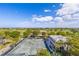 Aerial view showcasing a tennis court, golf course, surrounding lush greenery, and clear blue skies at 545 Sanctuary Dr # B806, Longboat Key, FL 34228