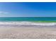 Waves gently lapping the shore on a beautiful white sandy beach with clear blue water at 545 Sanctuary Dr # B806, Longboat Key, FL 34228