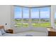 Bright bedroom has floor-to-ceiling windows showcasing waterfront and golf course views at 545 Sanctuary Dr # B806, Longboat Key, FL 34228