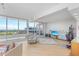 Bright living room showcasing stunning views through expansive windows, with a cozy seating area and a work space at 545 Sanctuary Dr # B806, Longboat Key, FL 34228