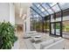 Bright and modern lobby area featuring a high glass ceiling, comfortable seating and lush indoor plants at 545 Sanctuary Dr # B806, Longboat Key, FL 34228