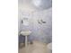 Unique powder room with pedestal sink, nautical themed artwork, and tiled flooring at 545 Sanctuary Dr # B806, Longboat Key, FL 34228