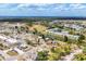 Scenic aerial view of a charming home near a canal, sports field, and community amenities under a bright, partly cloudy sky at 5602 Espanola Ave, North Port, FL 34287
