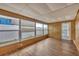 Bright sunroom with wood-paneled walls, multiple windows, and vinyl floors at 5602 Espanola Ave, North Port, FL 34287