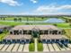 Stunning aerial view of condo building overlooking the golf course and lake with palm tree-lined entrance at 5664 Palmer Cir # 102, Bradenton, FL 34211