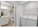 Convenient combination laundry and bathroom with modern white cabinetry and efficient washer and dryer at 5664 Palmer Cir # 102, Bradenton, FL 34211