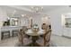 Cozy dining area with chandelier lighting and views into the bright kitchen and living areas at 5664 Palmer Cir # 102, Bradenton, FL 34211
