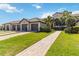 Charming villa with a tile roof, attached garage, brick paver driveway, and well-maintained landscaping at 5664 Palmer Cir # 102, Bradenton, FL 34211