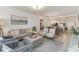 Bright living room with neutral furniture, tiled floors, and an open layout to the kitchen and dining area at 5664 Palmer Cir # 102, Bradenton, FL 34211