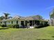 Nice backyard with a patio, a well-maintained lawn, and tropical landscaping at 5711 Garden Lakes Palm, Bradenton, FL 34203