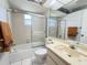 Bathroom featuring a shower-tub combination with a glass door and tiled surround at 5711 Garden Lakes Palm, Bradenton, FL 34203