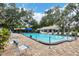 Resort-style pool with lounge chairs surrounded by mature trees, perfect for relaxation and recreation at 5711 Garden Lakes Palm, Bradenton, FL 34203