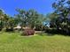 A lush front lawn with mature trees and tropical plants enhances the curb appeal at 5711 Garden Lakes Palm, Bradenton, FL 34203