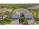 Aerial view showcasing the property's tile roof, brick driveway, lush landscaping, and scenic surroundings at 5934 Guarino Dr, Sarasota, FL 34238