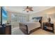 Bedroom features plantation shutters, ceiling fan, and neutral walls, with a dark wood sleigh bed and side table at 5934 Guarino Dr, Sarasota, FL 34238