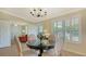 Dining room features a chandelier, plantation shutters, and views of the living room, and front entryway at 5934 Guarino Dr, Sarasota, FL 34238