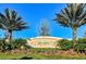 Elegant community entrance sign framed by lush palm trees and colorful landscaping at 5934 Guarino Dr, Sarasota, FL 34238