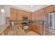 Eat-in kitchen showcasing stainless appliances, including a refrigerator, microwave, range, granite counters and breakfast bar at 5934 Guarino Dr, Sarasota, FL 34238
