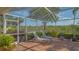 Relaxing screened lanai featuring lounge chairs with lush landscaping and a serene lake view at 5934 Guarino Dr, Sarasota, FL 34238