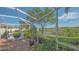 Screened lanai showcasing a serene lake view and lush backyard landscaping at 5934 Guarino Dr, Sarasota, FL 34238