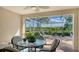 Screened lanai with a round table, seating and views of the lake at 5934 Guarino Dr, Sarasota, FL 34238