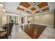 Bright, open living area with a decorative wood ceiling, tile floors, and neutral walls at 6390 Yellow Wood Pl, Sarasota, FL 34241