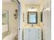 Well-lit bathroom featuring a modern vanity with a decorative mirror and a glass-enclosed shower at 7507 Preserves Ct # 7507, Sarasota, FL 34243