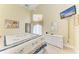 Cozy bedroom with a ceiling fan, tv, a mirror and a white wicker dresser at 7507 Preserves Ct # 7507, Sarasota, FL 34243