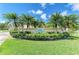 Beautiful landscaped entrance to The Preserves with lush greenery and mature palm trees on a sunny day at 7507 Preserves Ct # 7507, Sarasota, FL 34243