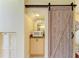Small kitchenette with a microwave and cabinets, accessed through a wooden sliding barn door at 7507 Preserves Ct # 7507, Sarasota, FL 34243