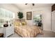 Airy bedroom featuring a sunny window, a quaint headboard, and a decorative plant, creating a cozy ambiance at 7685 Plantation Cir # B, University Park, FL 34201