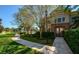 Well-maintained clubhouse with a paved walkway, mature trees, and lush greenery at 7685 Plantation Cir # B, University Park, FL 34201