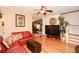 Comfortable living room features hardwood floors, a ceiling fan, and a cozy red leather sofa at 7685 Plantation Cir # B, University Park, FL 34201