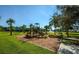 Gathering-friendly community playground with a playset, lush greenery, and serene walking paths for outdoor fun at 7685 Plantation Cir # B, University Park, FL 34201