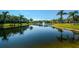 Picturesque pond lined with townhomes and palm trees, creating a serene atmosphere at 7685 Plantation Cir # B, University Park, FL 34201