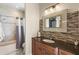 Bathroom with mosaic tile backsplash, decorative mirror, and tub with shower at 8058 Santa Cruz Dr, Port Charlotte, FL 33981
