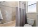 Close-up of bathroom with tiled wall, shower curtain, and toilet at 8058 Santa Cruz Dr, Port Charlotte, FL 33981