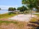 Scenic beach volleyball court with water views, picnic areas, and palm trees for a relaxing outdoor experience at 8058 Santa Cruz Dr, Port Charlotte, FL 33981